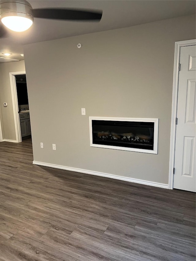 unfurnished living room featuring dark wood-style floors and baseboards