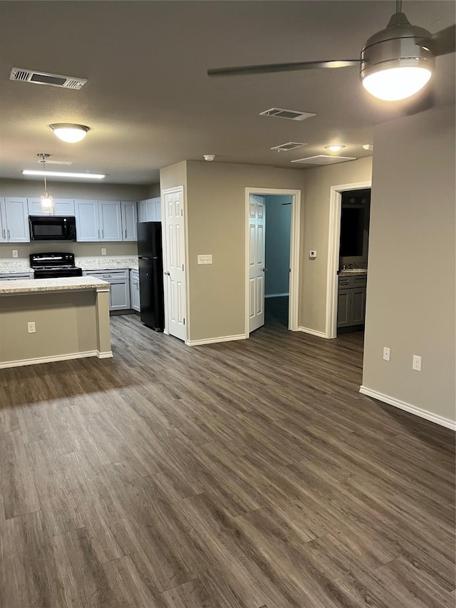 kitchen featuring dark wood-type flooring, baseboards, decorative light fixtures, and black appliances