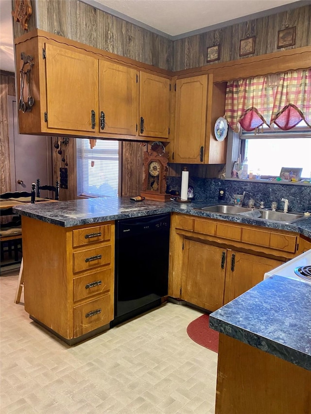 kitchen with kitchen peninsula, wooden walls, sink, and black dishwasher