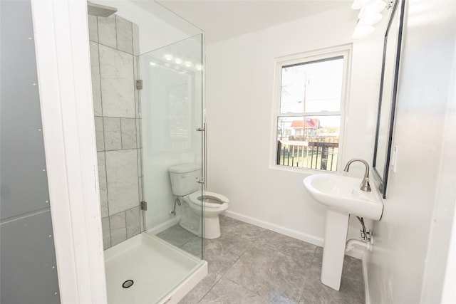 bathroom with toilet, tiled shower, tile floors, and sink