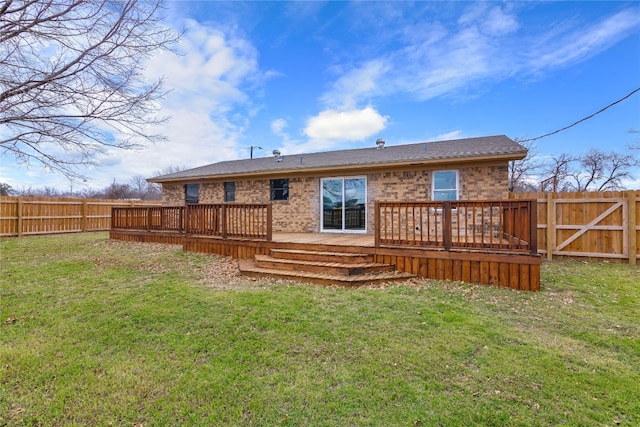 rear view of property with a wooden deck and a yard