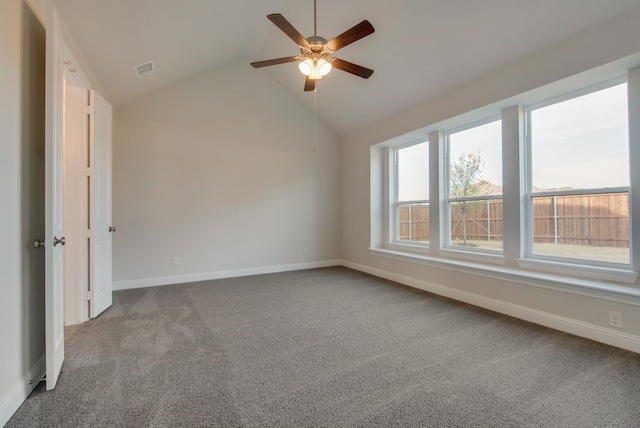 carpeted empty room with plenty of natural light, ceiling fan, and vaulted ceiling