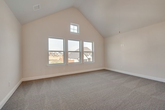 spare room featuring carpet floors and vaulted ceiling