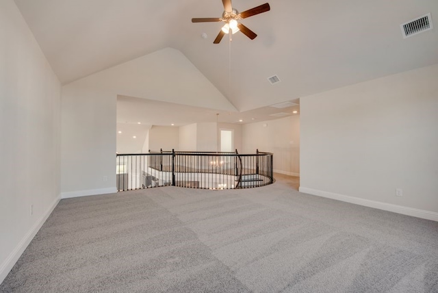 carpeted empty room with high vaulted ceiling and ceiling fan