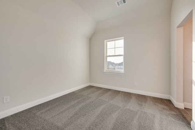 empty room with carpet flooring and lofted ceiling