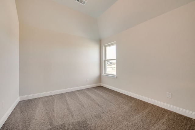 carpeted empty room featuring vaulted ceiling