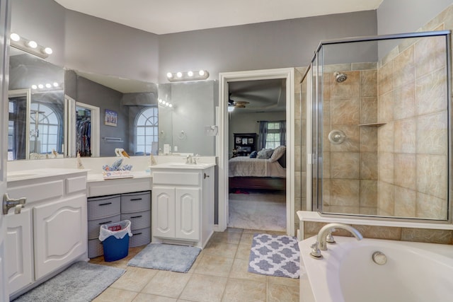 bathroom with tile flooring, ceiling fan, separate shower and tub, dual sinks, and oversized vanity