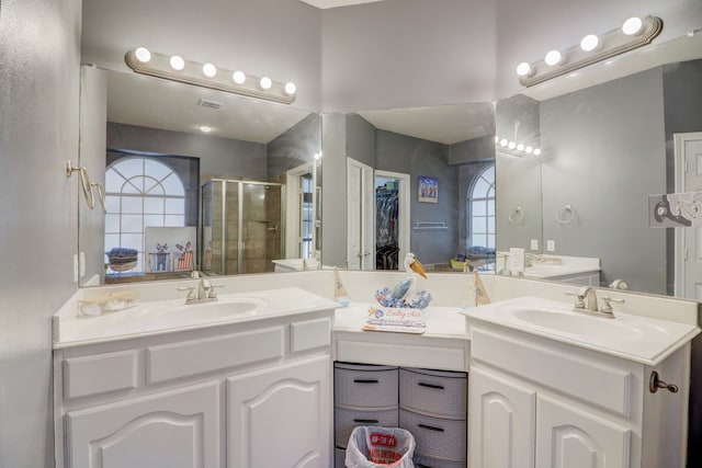 bathroom featuring a wealth of natural light, an enclosed shower, and double vanity