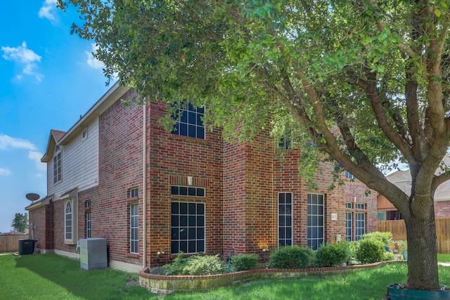 view of side of home with a yard and central AC unit