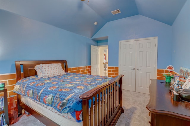 bedroom featuring lofted ceiling, carpet, and a closet