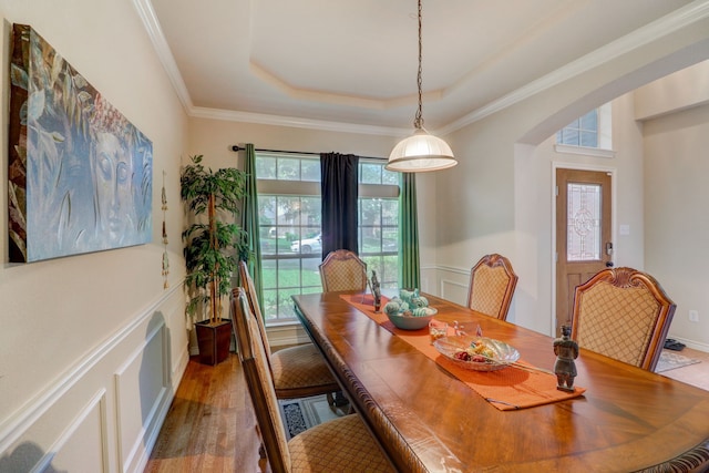 dining space featuring hardwood / wood-style flooring and a tray ceiling