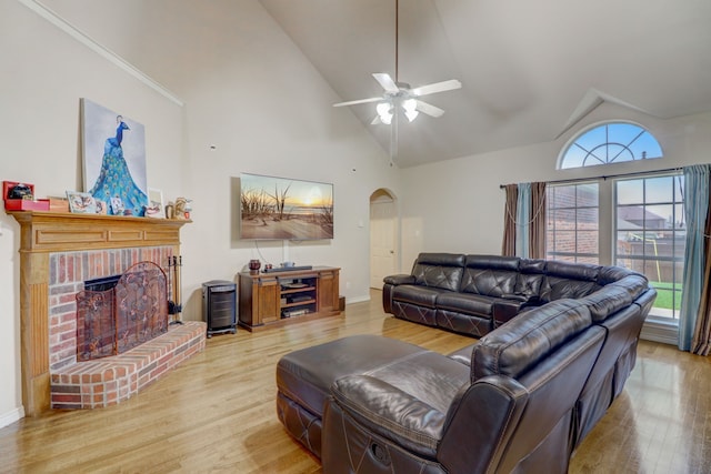 living room with wood-type flooring, a fireplace, high vaulted ceiling, and ceiling fan