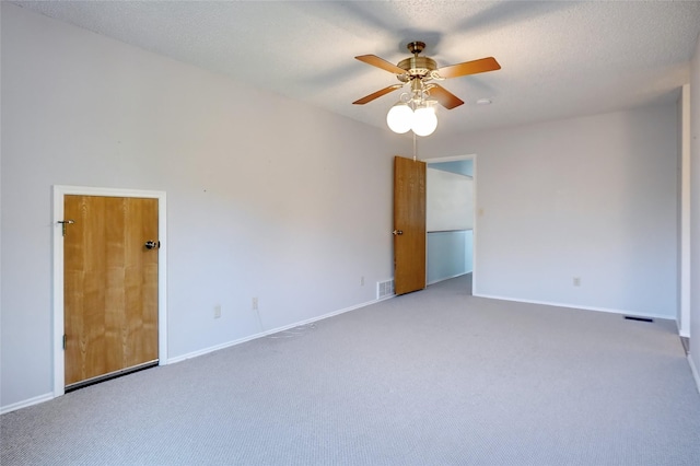 unfurnished room with carpet flooring, ceiling fan, and a textured ceiling