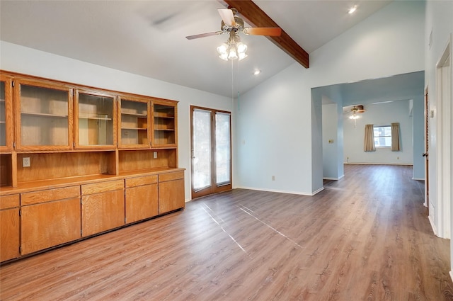 unfurnished living room featuring lofted ceiling with beams, ceiling fan, and light hardwood / wood-style floors