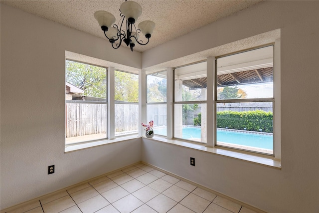 unfurnished sunroom featuring an inviting chandelier and plenty of natural light