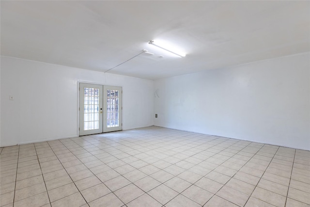 tiled spare room featuring french doors