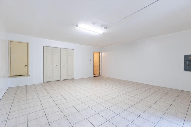 interior space with electric panel, a closet, and light tile patterned floors