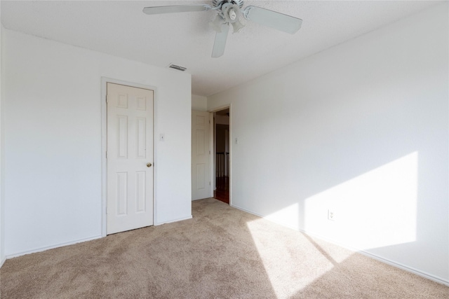 carpeted spare room featuring ceiling fan