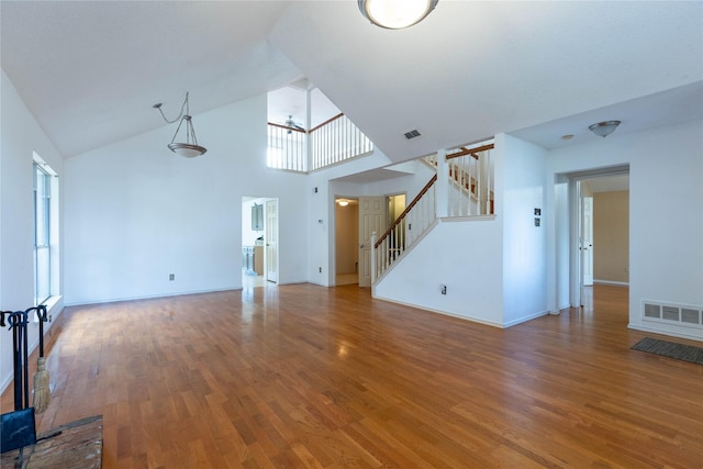 unfurnished living room featuring ceiling fan, wood-type flooring, and high vaulted ceiling