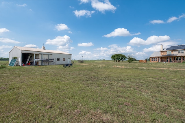 view of yard with an outdoor structure and a rural view