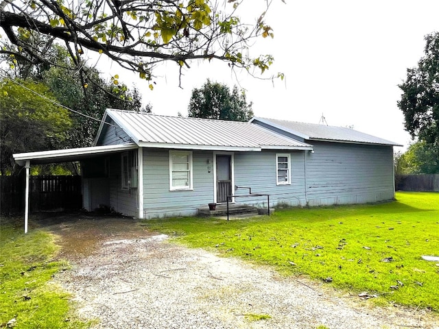 view of front of house featuring a carport and a front lawn