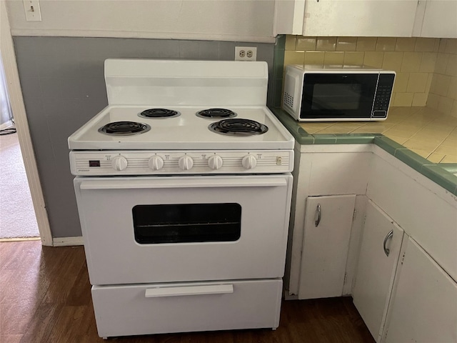 kitchen with white cabinetry, backsplash, dark wood-type flooring, tile countertops, and white range with electric stovetop