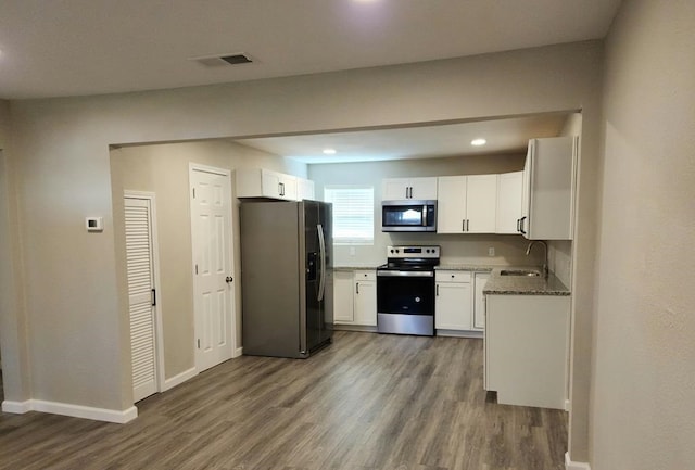 kitchen with white cabinets, hardwood / wood-style floors, and stainless steel appliances