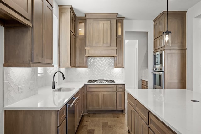 kitchen featuring pendant lighting, tasteful backsplash, appliances with stainless steel finishes, dark hardwood / wood-style floors, and sink