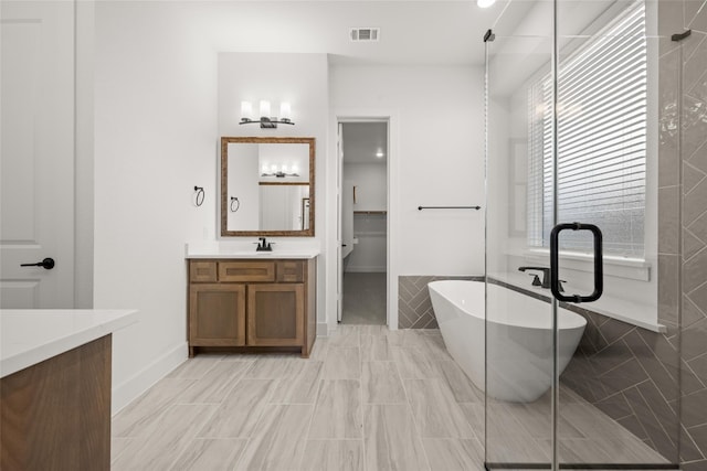 bathroom featuring a bath, tile floors, and large vanity