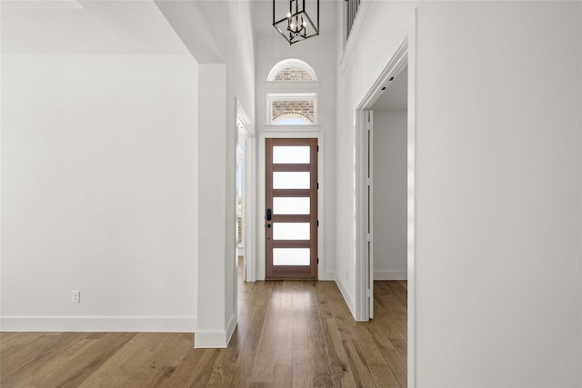 entrance foyer featuring an inviting chandelier, a high ceiling, and light hardwood / wood-style floors