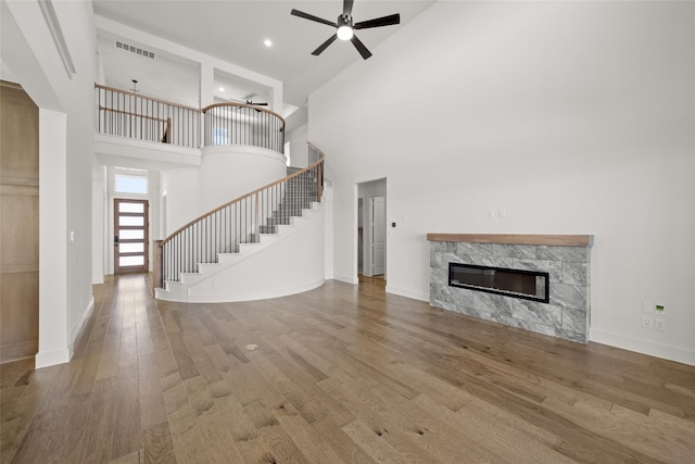 unfurnished living room featuring high vaulted ceiling, ceiling fan, and hardwood / wood-style flooring