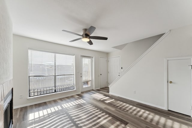 unfurnished living room with ceiling fan and dark hardwood / wood-style flooring