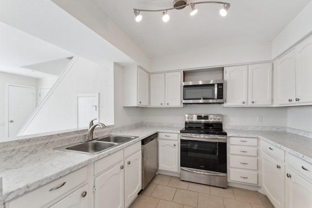 kitchen with white cabinets, light tile patterned flooring, sink, and stainless steel appliances