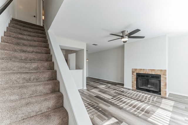 stairway featuring hardwood / wood-style flooring and ceiling fan