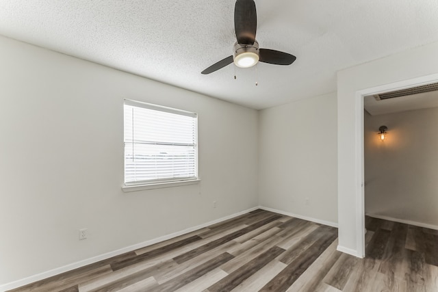 unfurnished room with hardwood / wood-style floors, a textured ceiling, and ceiling fan