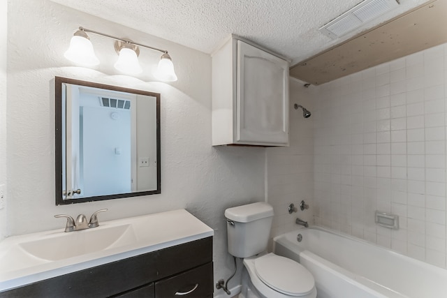 full bathroom featuring vanity, toilet, a textured ceiling, and tiled shower / bath