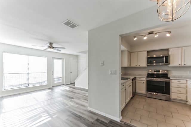 kitchen featuring ceiling fan with notable chandelier, white cabinetry, sink, and appliances with stainless steel finishes