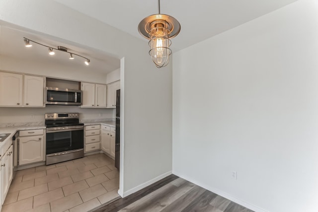 kitchen with hardwood / wood-style floors, stainless steel appliances, and white cabinetry