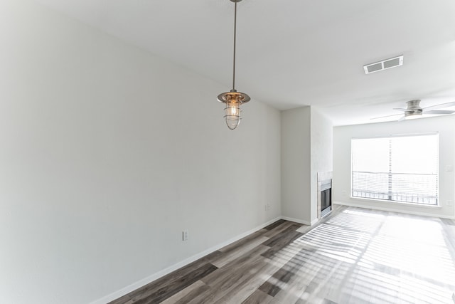 unfurnished living room with dark hardwood / wood-style floors and ceiling fan