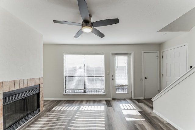 unfurnished living room with heating unit, dark hardwood / wood-style floors, and ceiling fan