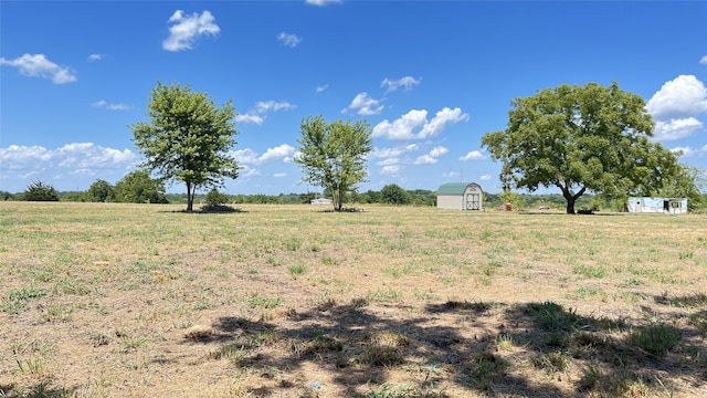 view of yard with a storage unit and a rural view