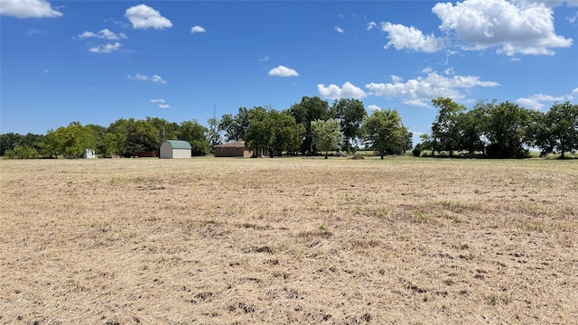 view of yard featuring a rural view and an outdoor structure