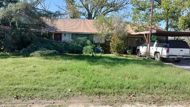 ranch-style house with a front yard and a carport