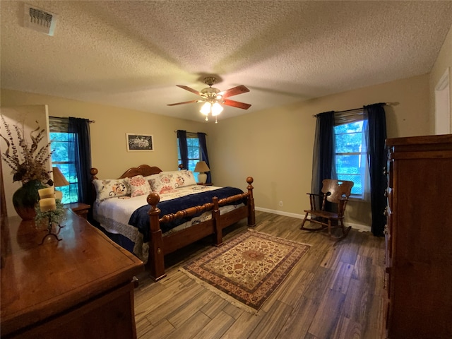 bedroom featuring hardwood / wood-style flooring, ceiling fan, and a textured ceiling