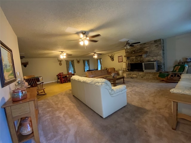 living room with a textured ceiling, light carpet, ceiling fan, and a fireplace