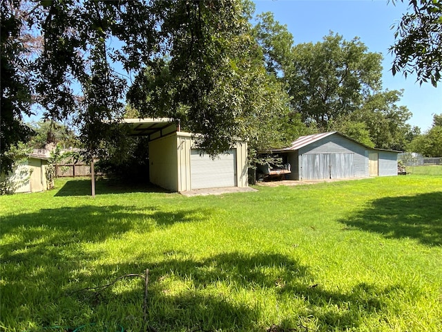 view of yard featuring a garage and an outdoor structure