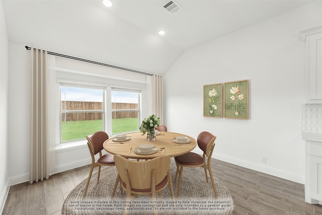 dining room featuring lofted ceiling and wood-type flooring