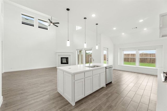 kitchen featuring sink, ceiling fan, an island with sink, white cabinets, and stainless steel dishwasher