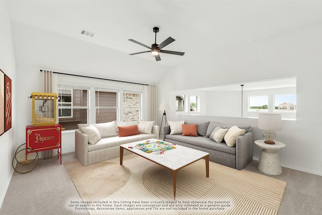 carpeted living room with ceiling fan and vaulted ceiling