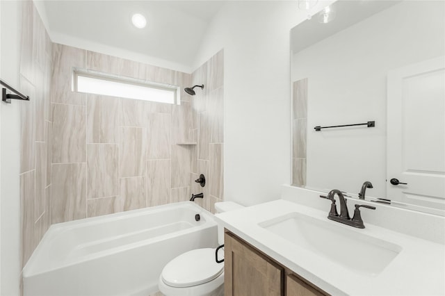 full bathroom featuring tiled shower / bath, vanity, and toilet